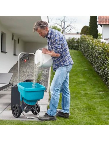 señor en el jardín echando fertilizante en carro Esparcidor XL de Gardena