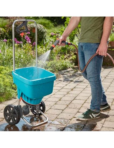 ambiente jardín con señor regando el carro Esparcidor XL de Gardena con pistola de riego Gardena